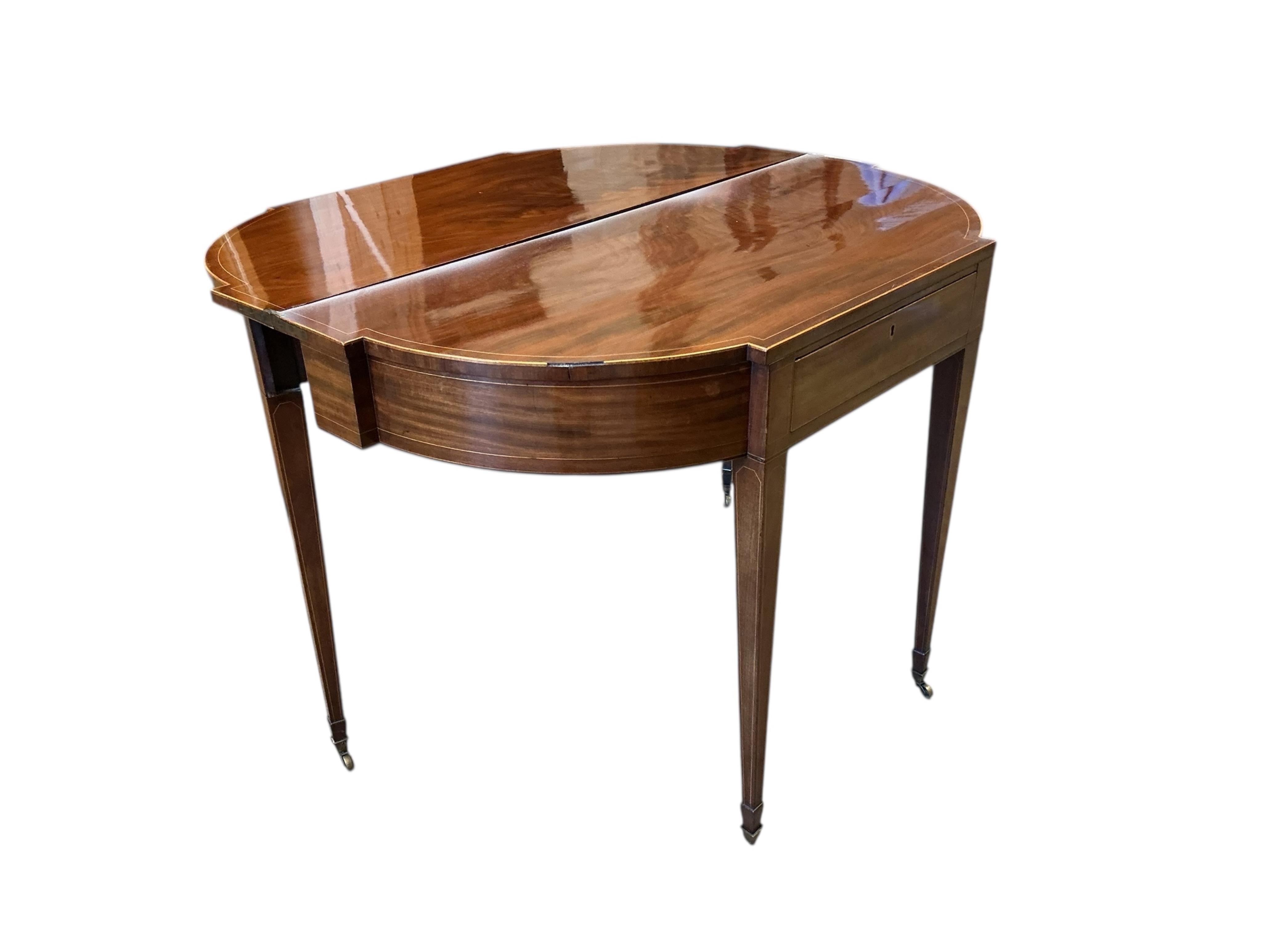 A George III boxwood strung mahogany breakfront folding tea table with frieze drawer, width 101cm, depth 47cm, height 74cm